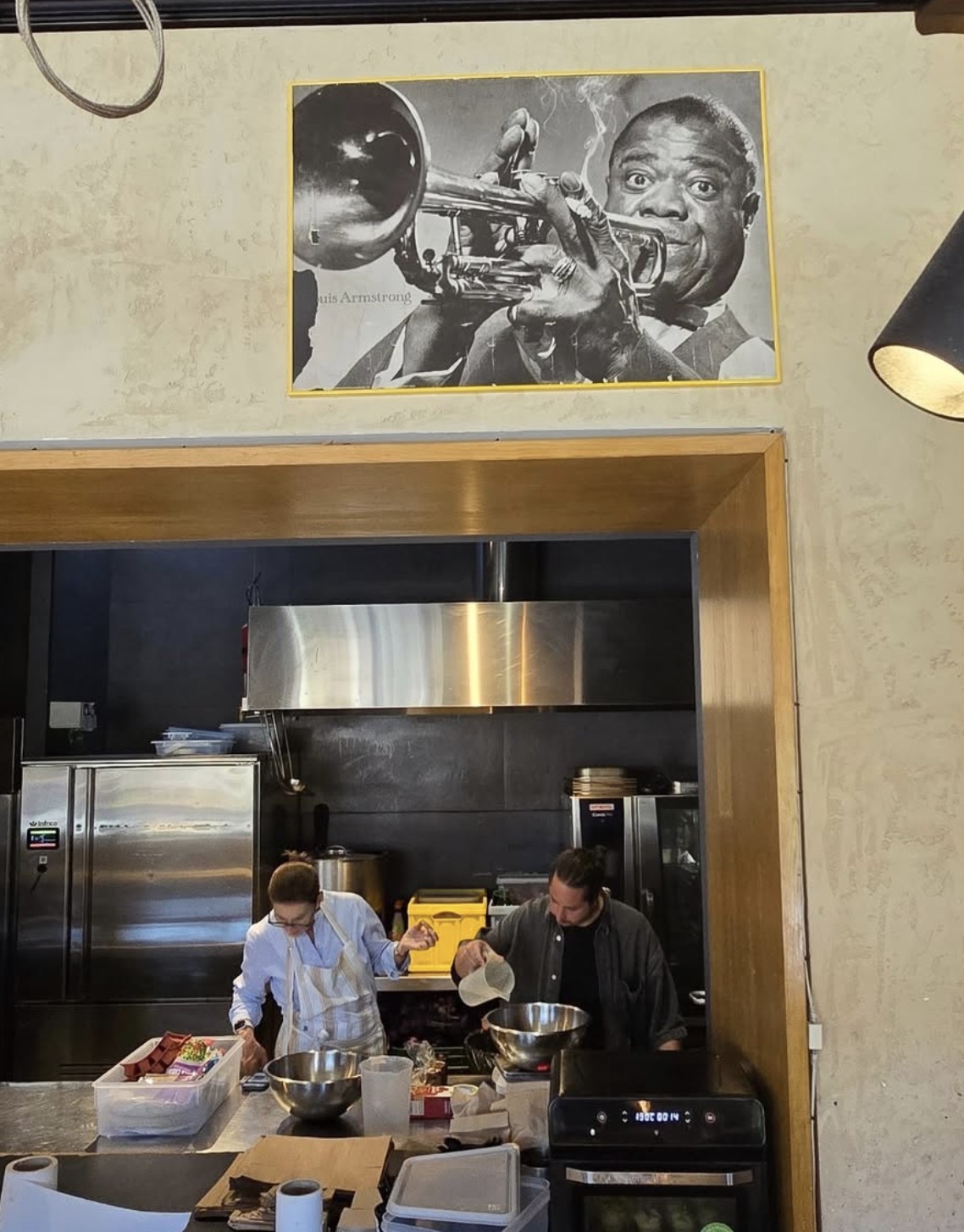Pase de cocina de Makan bajo el cuadro de Louis Armstrong